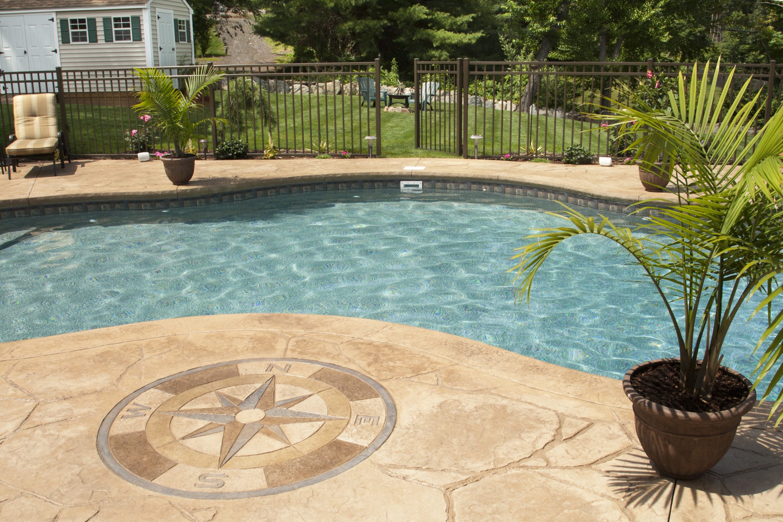 concrete deck with compass at a freeform poolside concrete deck with compass at a freeform poolside