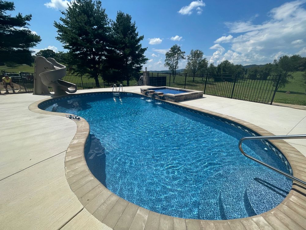 freeform vinyl liner pool in Virginia backyard with tanning ledge and waterslide