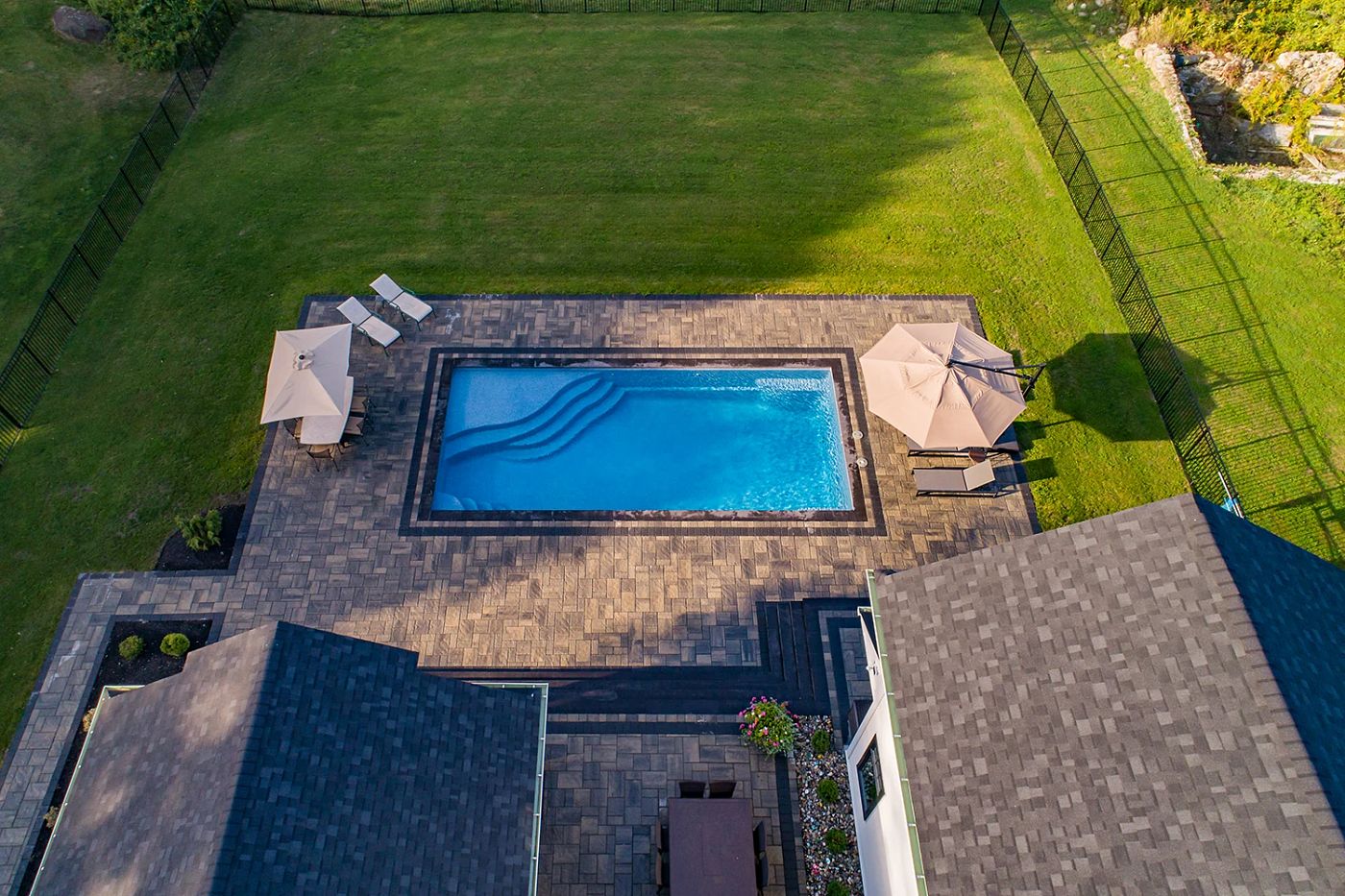bird’s eye view of fiberglass pool in backyard surrounded by fence