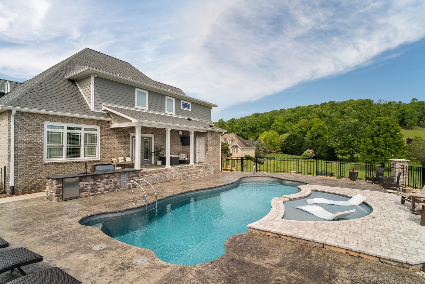 freeform fiberglass pool in backyard with tanning ledge
