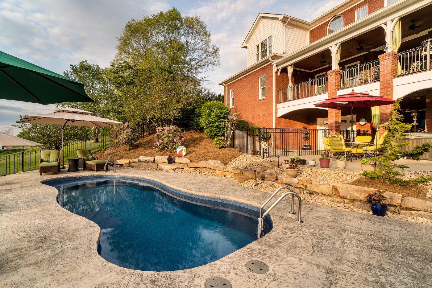 freeform fiberglass pool in a sloped backyard
