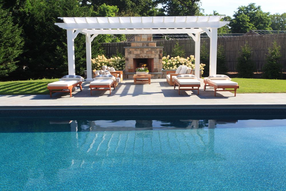 backyard with pool, fireplace, and lounge furniture underneath a pergola