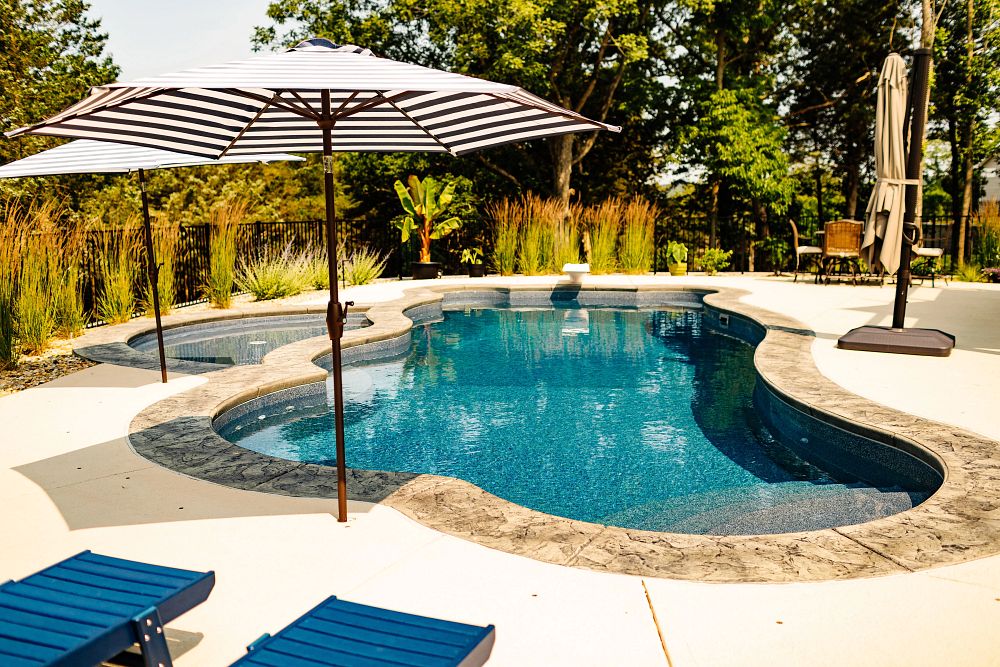 large freeform fiberglass pool in big backyard