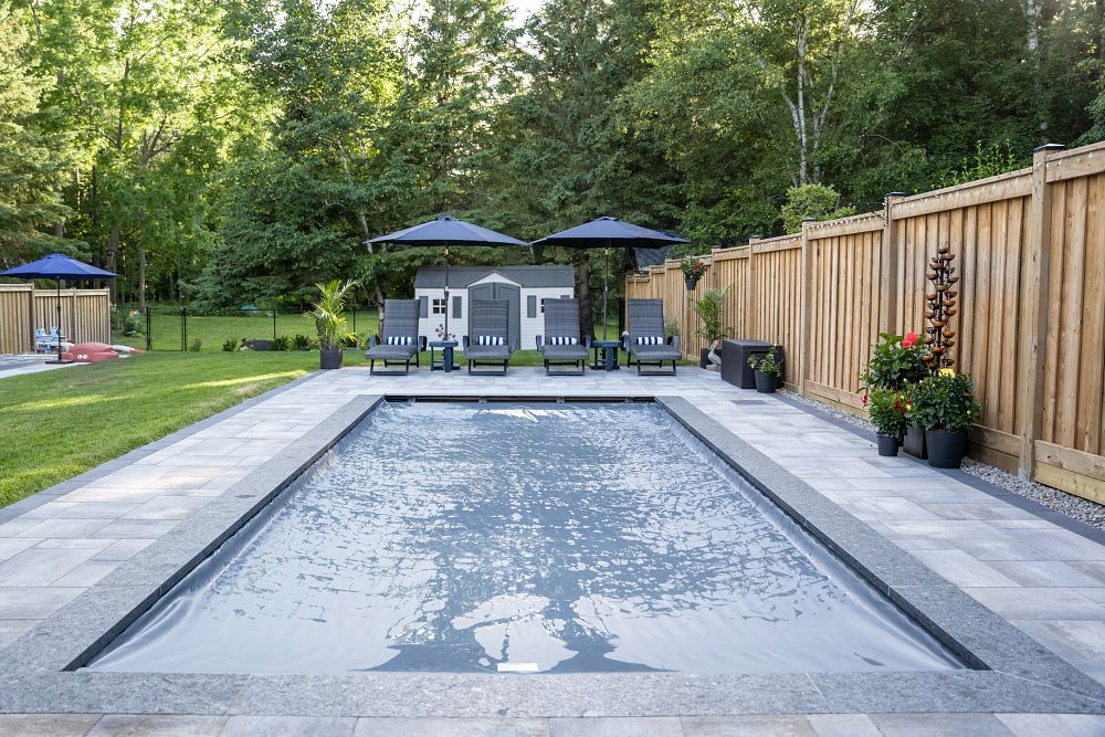 Olympia 12 Fiberglass Shape | Photo courtesy of Scenic View Landscaping Inc rectangular fiberglass pool in Canadian backyard with safety cover closed