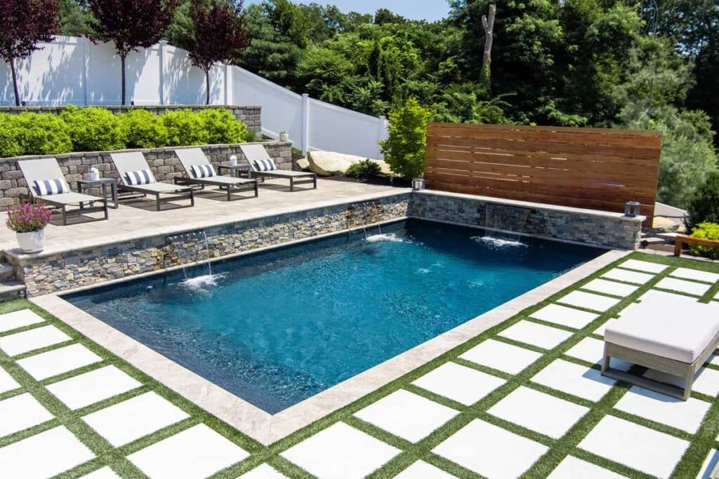 Contemporary plunge pool with geometric patio and sun loungers